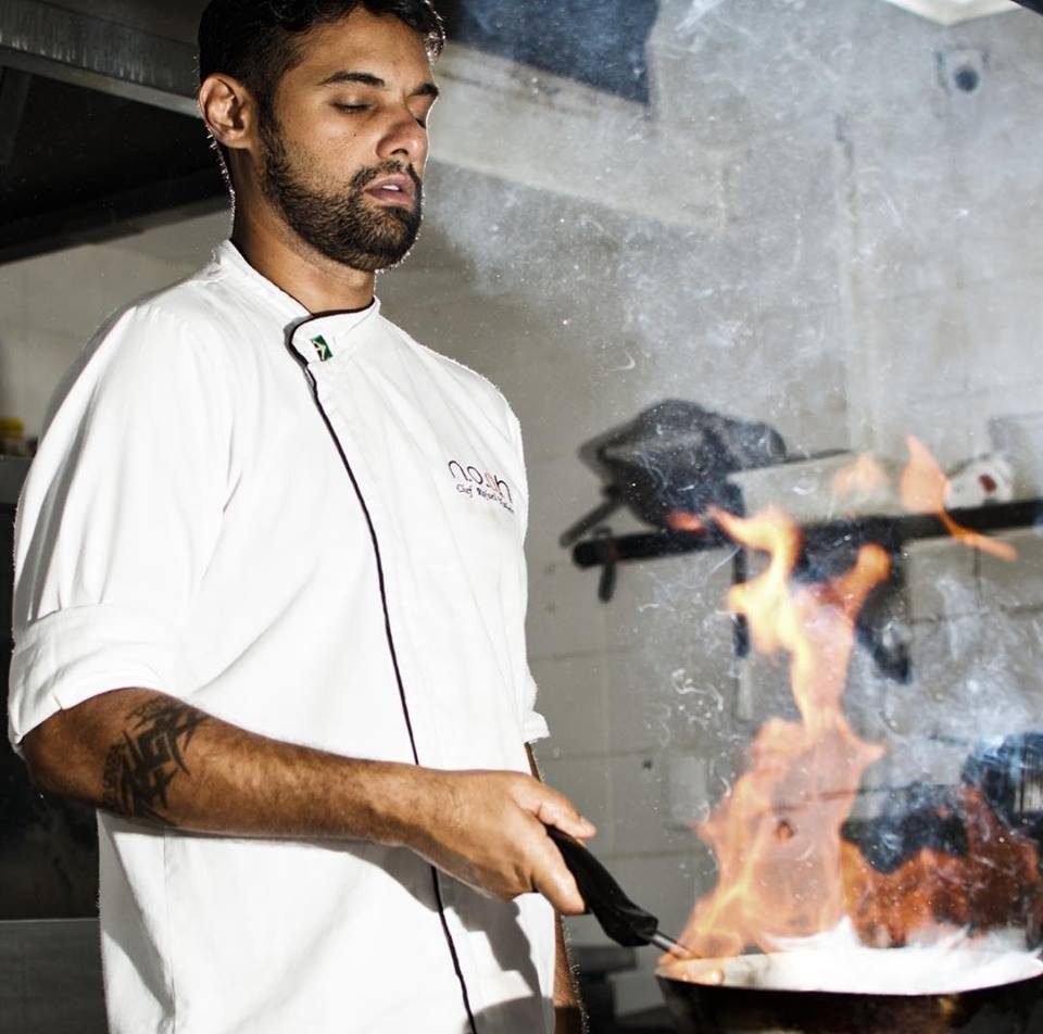 Chef flambando na frigideira com chamas altas
