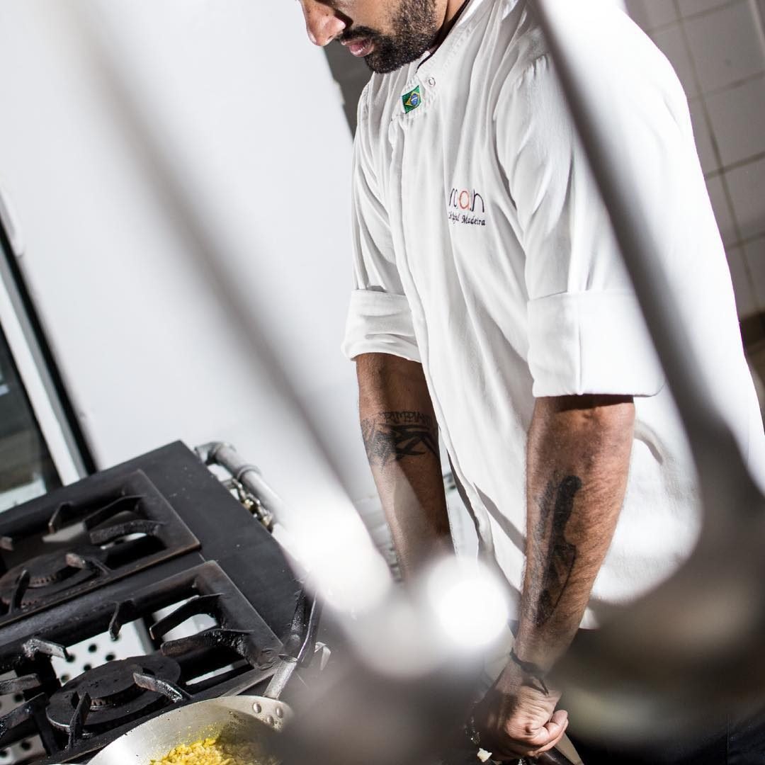 Chef Rafael Madeira finalizando prato no fogão industrial