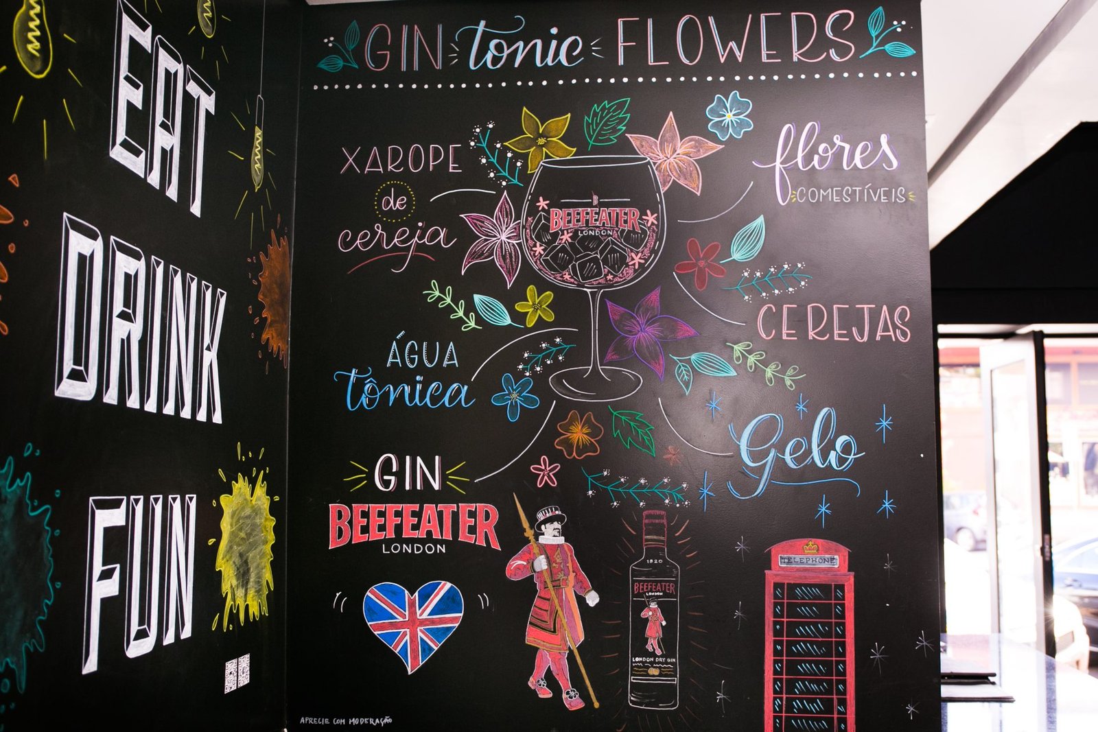 Lousa Eat Drink Fun e gin tônica ilustrada a giz