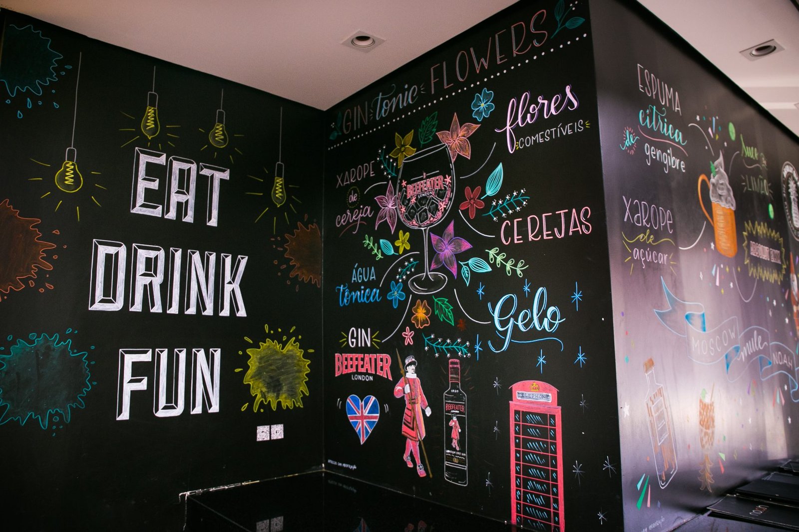 Paredes de lousa com as ilustrações dos drinks da casa