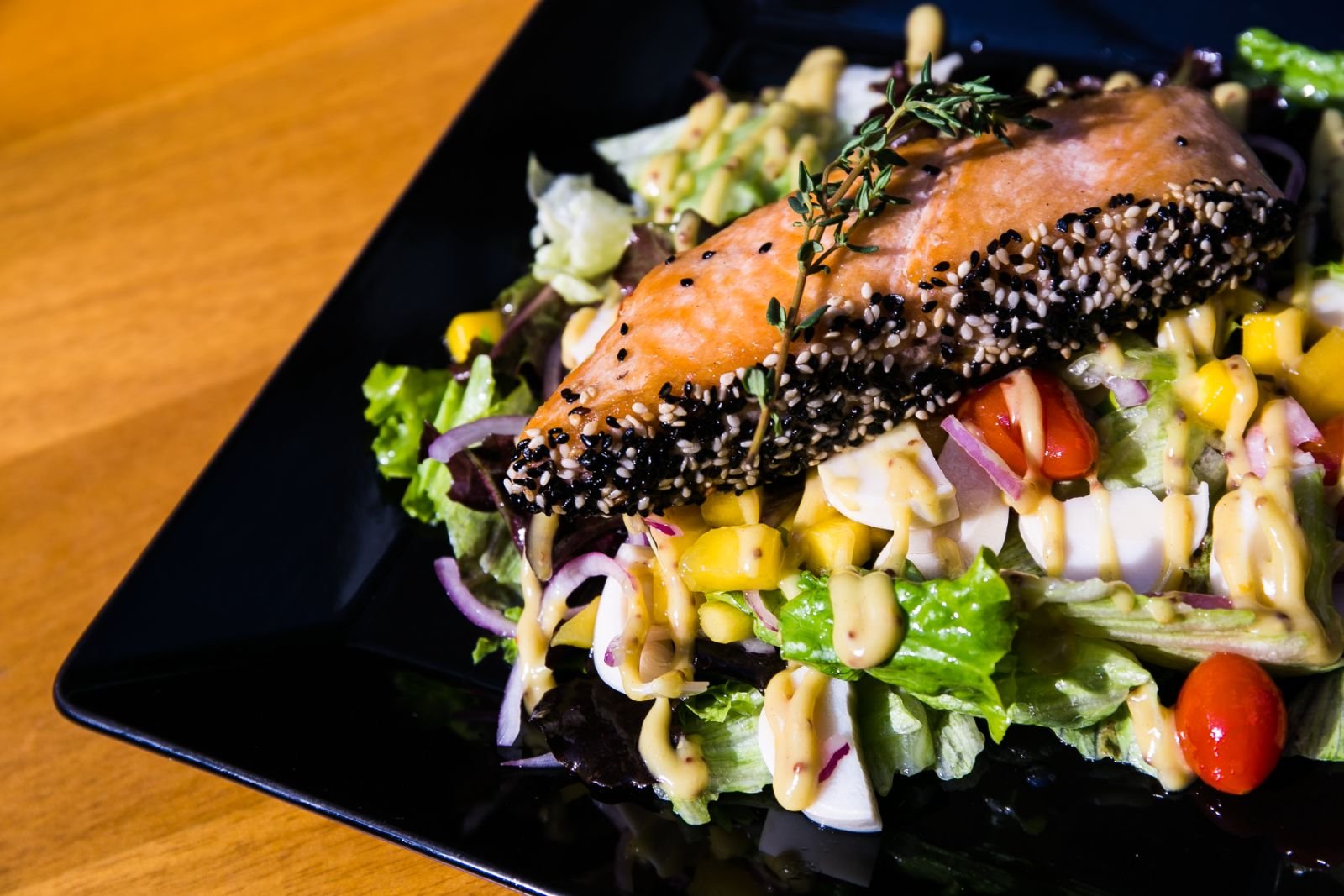 Posta de salmão com gergelim sobre salada